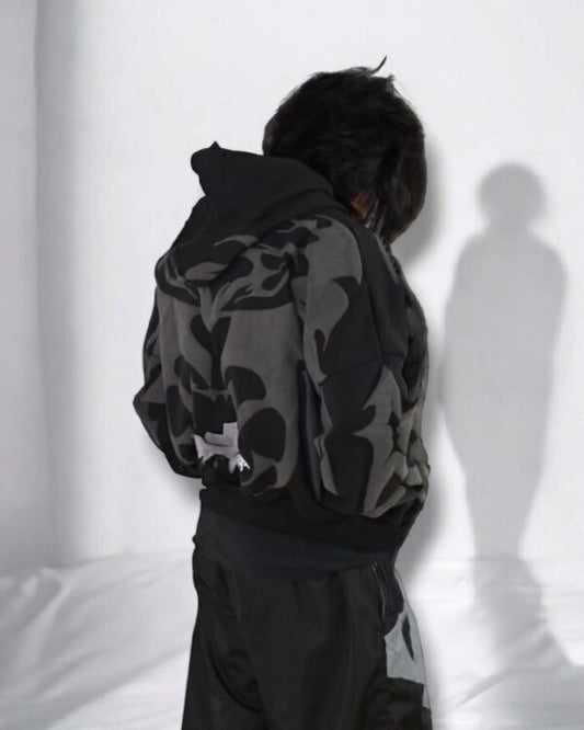 Model wearing oversized tribal shadow depth black hoodie, showcasing urban Indian streetwear with dark abstract patterns.