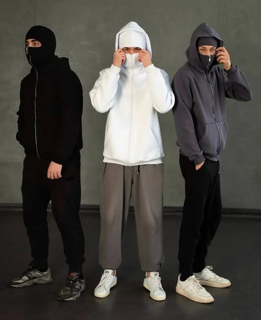 Trio of Ninja Hoodies in black, white, and grey with built-in balaclava masks, showcasing unisex streetwear style for winter and casual layering.
