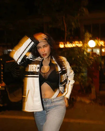 White Mercedes Jacket - Leather F1 worn by model at night, featuring bold MERCEDES branding and sporty design. Ideal for motorsport streetwear style.