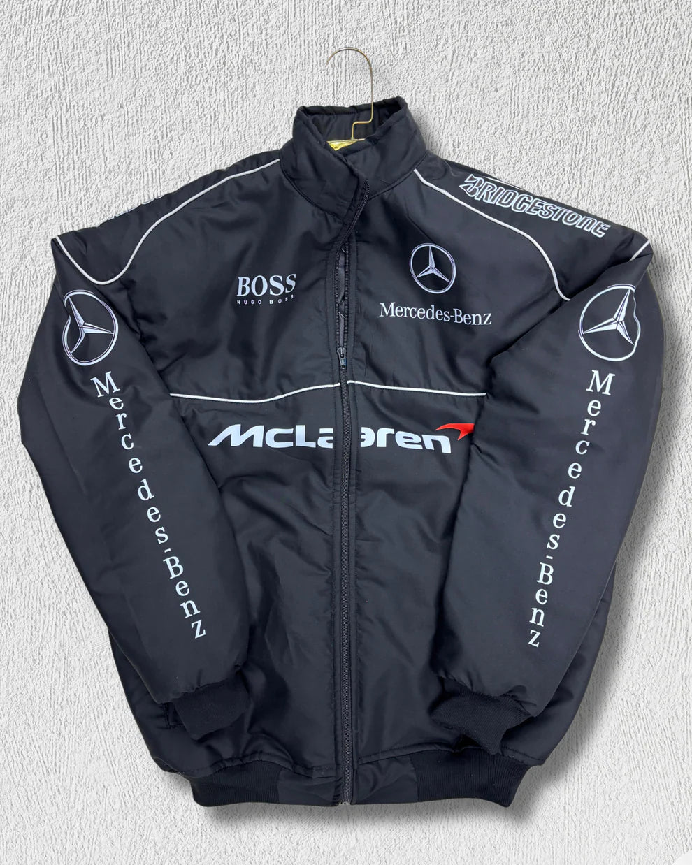 Front view of McLaren Puffer Jacket - Unisex Racing, featuring Mercedes-Benz and Bridgestone logos, wind-resistant streetwear design.
