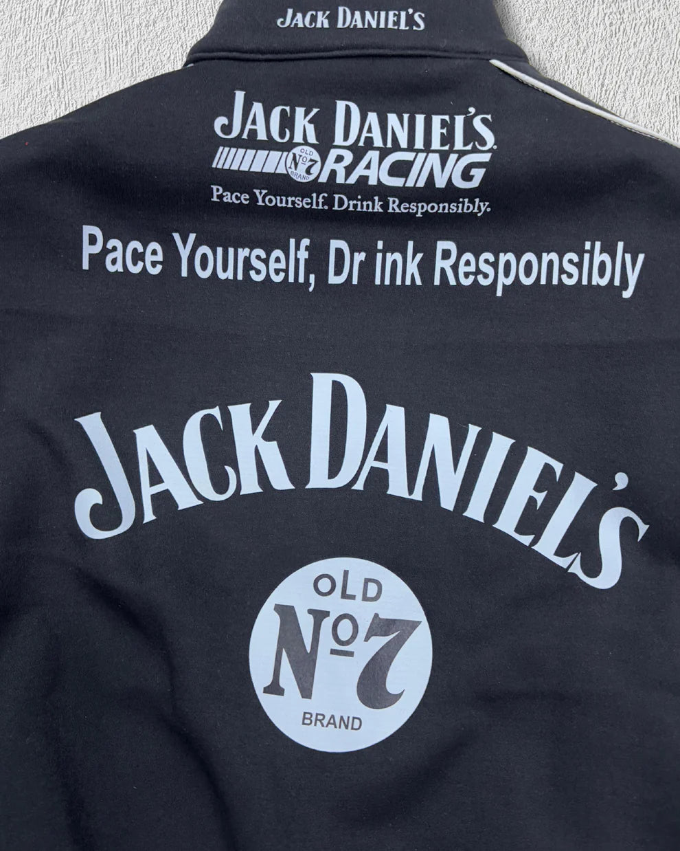 Back detail of Jack Daniel’s Printed Puffer Jacket – Unisex Streetwear with large Old No. 7 logo and 'Pace Yourself, Drink Responsibly' slogan.