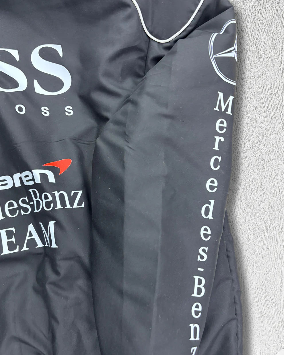 Zoomed-in sleeve detail of McLaren Puffer Jacket with Mercedes-Benz and Bridgestone logos, highlighting high-quality stitching and sporty design.
