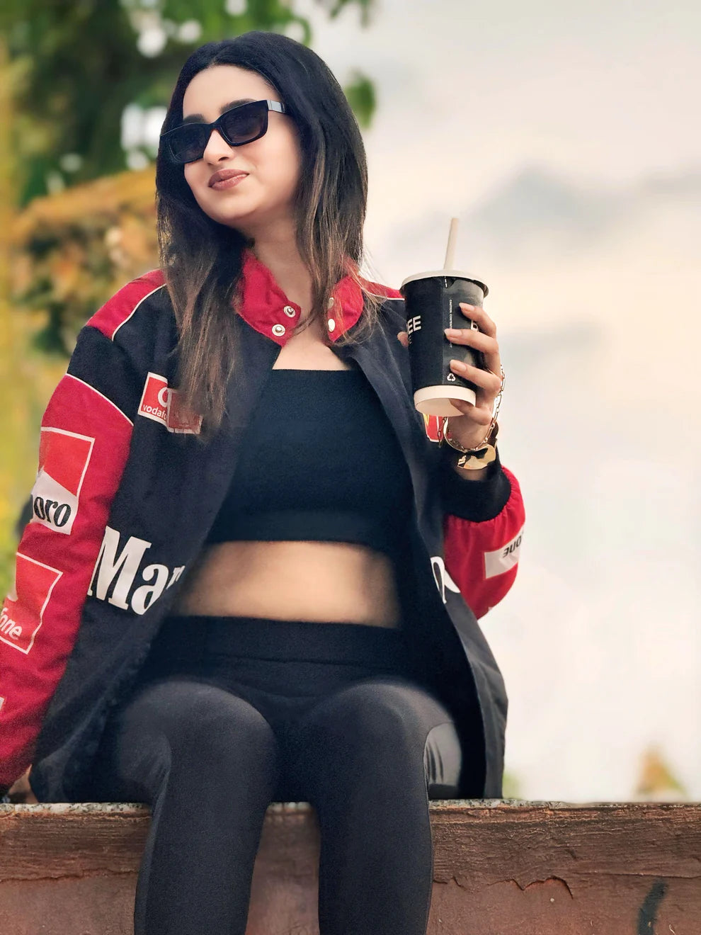 Seated model in Marlboro Racing Puffer Jacket – Motorsport Luxury Edition, showcasing comfort and luxury appeal with detailed sponsor patches.