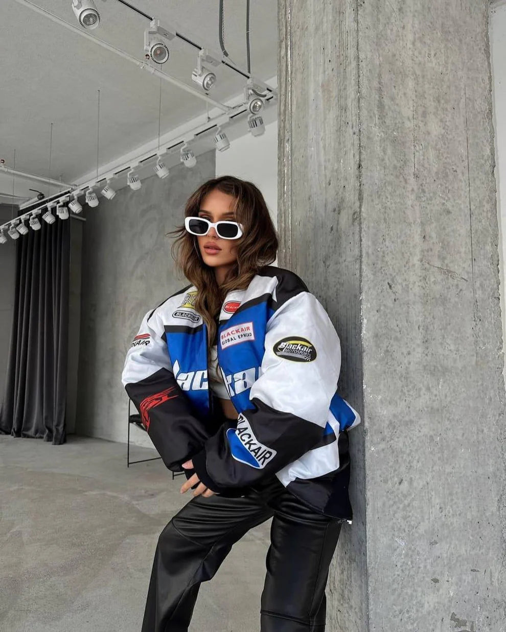 BlackAir Motorsport Jacket – NASCAR Printed Streetwear Drop styled with black leather pants. Bold racing patches and oversized fit for urban edge.