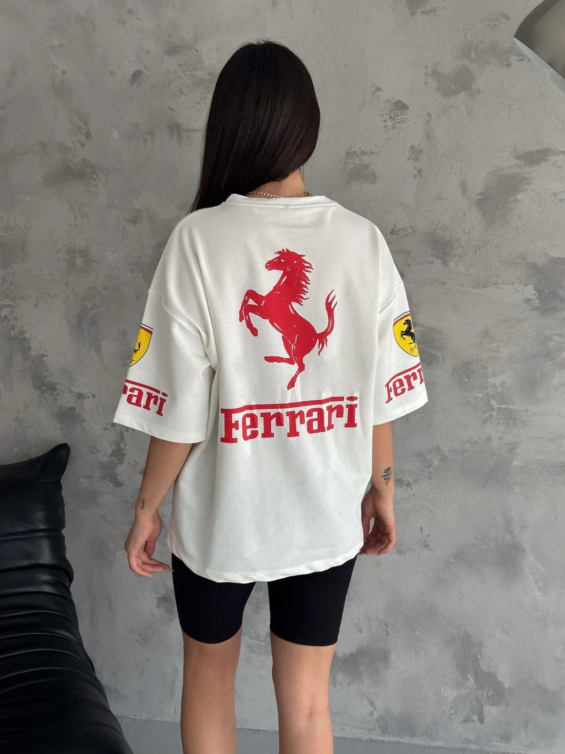 Back view of a woman wearing a white Cotton Racing T-Shirt with Ferrari logo, part of Women's F1 Fan Tees in Motorsport Comfort collection.