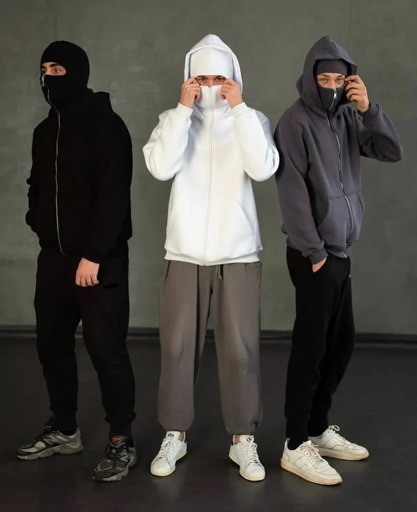 Trio of Ninja Hoodies in black, white, and grey with built-in balaclava masks, showcasing unisex streetwear style for winter and casual layering.