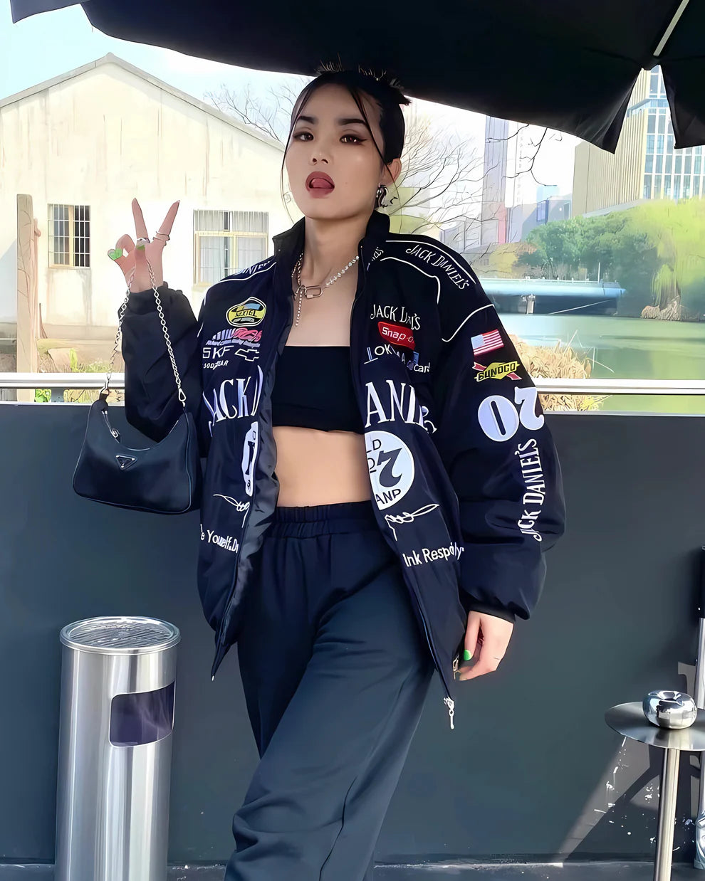 Model wearing Jack Daniel’s Printed Puffer Jacket – Unisex Streetwear with bold logos and racing-inspired patches, styled with black pants.