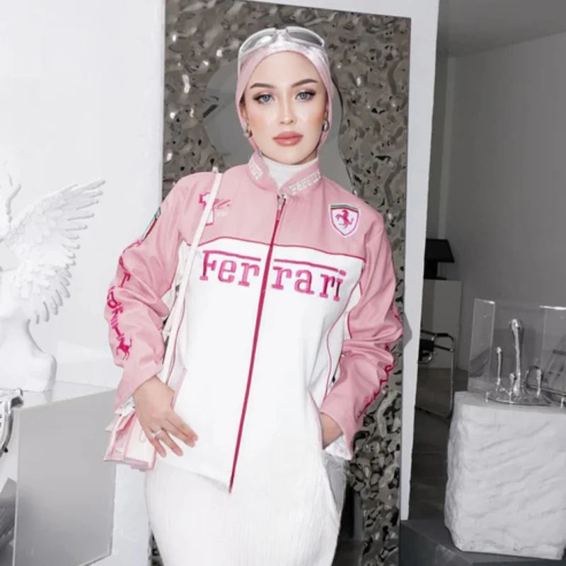 Model wearing Ferrari Pink and White Vintage Racing Vegan Leather Jacket indoors. Trendy sustainable jacket with bold Ferrari logo.