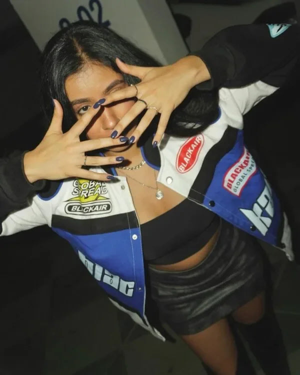 Bold Blackair Racer Jacket with retro racing patches, styled with dark nails and layered necklaces for a standout streetwear look.